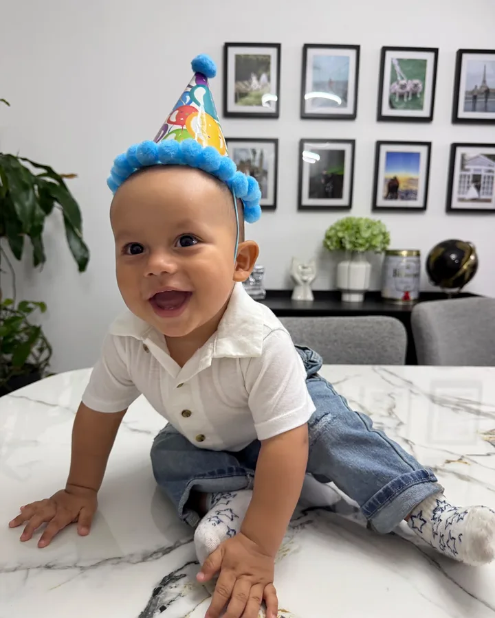 Julián, de 9 meses, sonriendo con un gorro de cumpleaños.